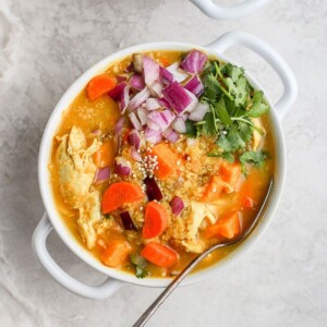 A bowl of curry chicken soup with sweet potato.