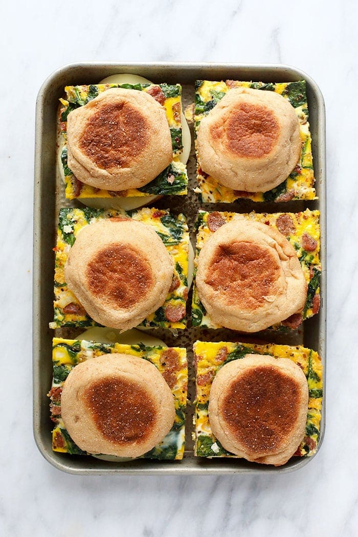 freezer breakfast sandwiches on a sheet pan ready to be wrapped and frozen.