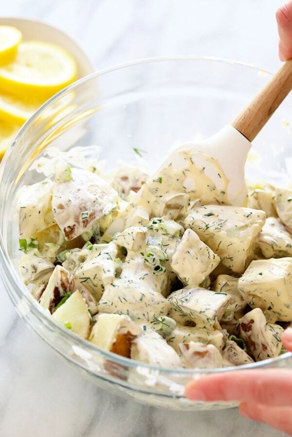 vegan potato salad being stirred with a spatula