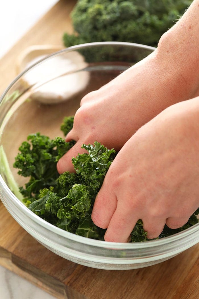 Two hands massaging kale