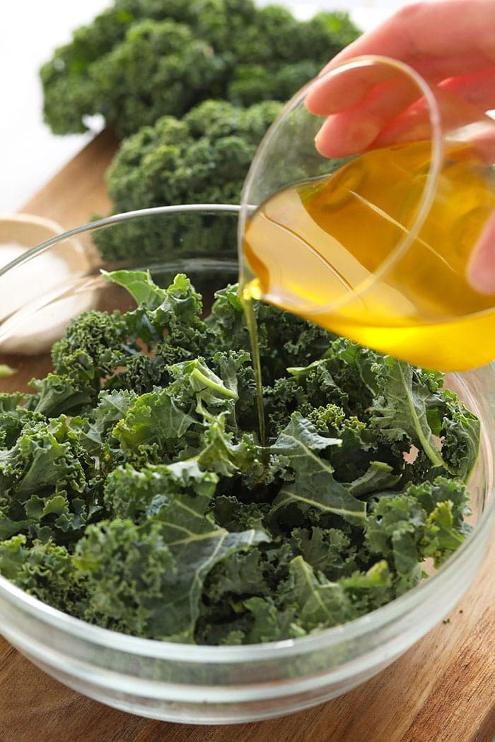 Pouring olive oil over kale