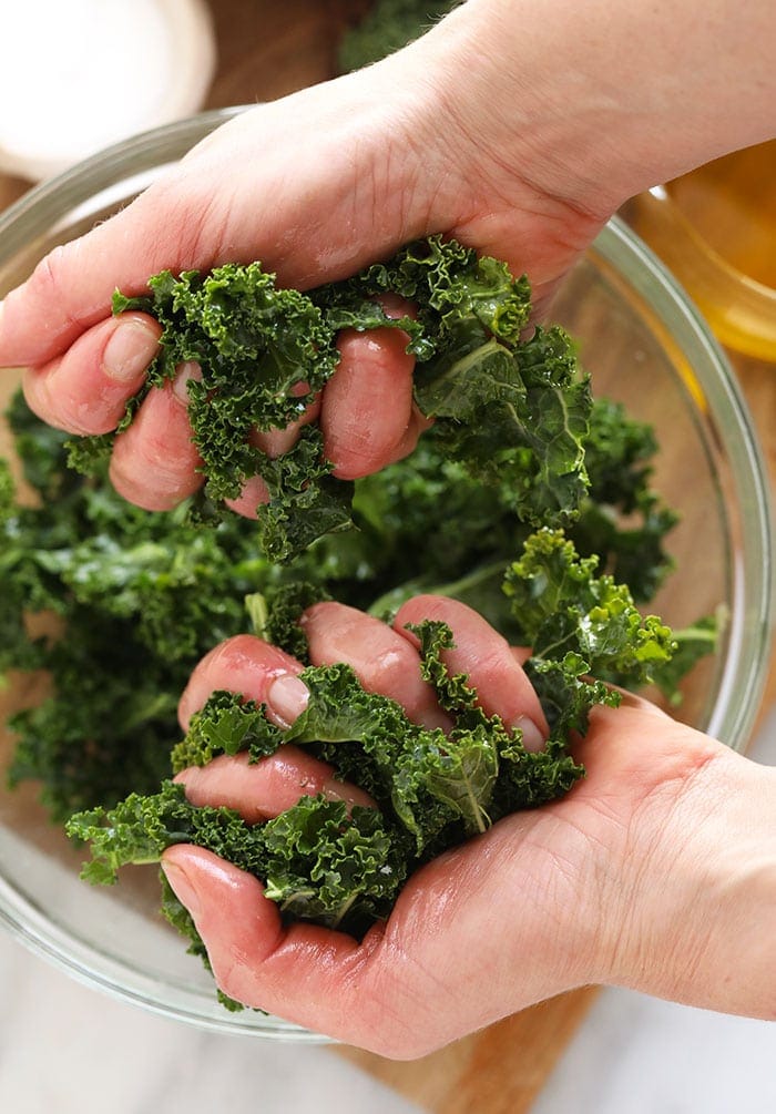 two hands massaging kale