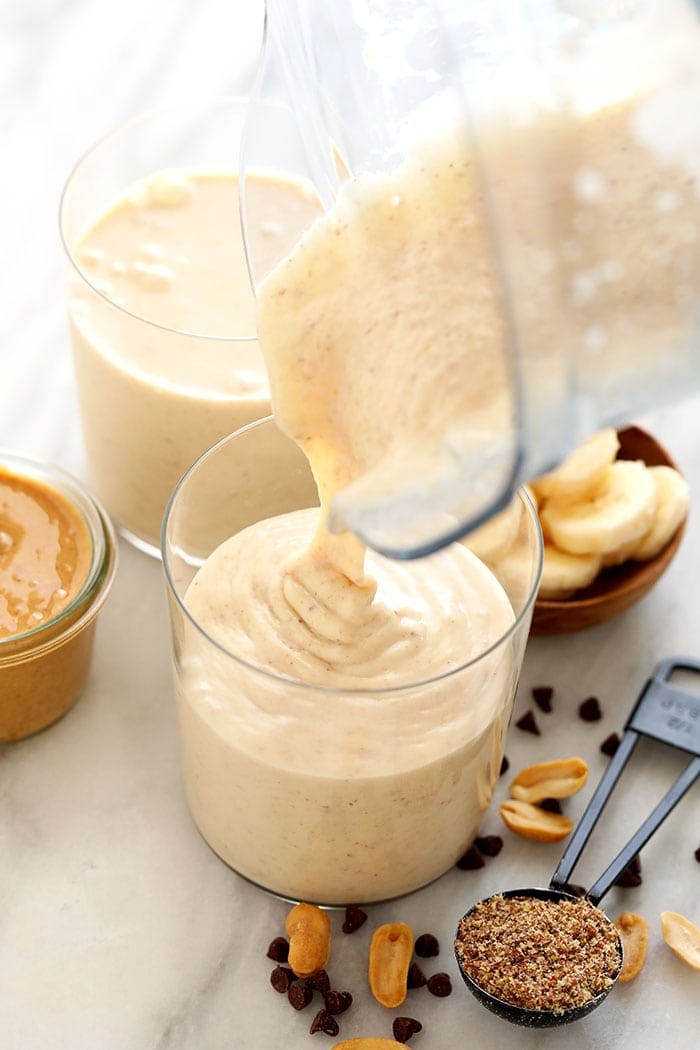 pouring smoothie into glass.