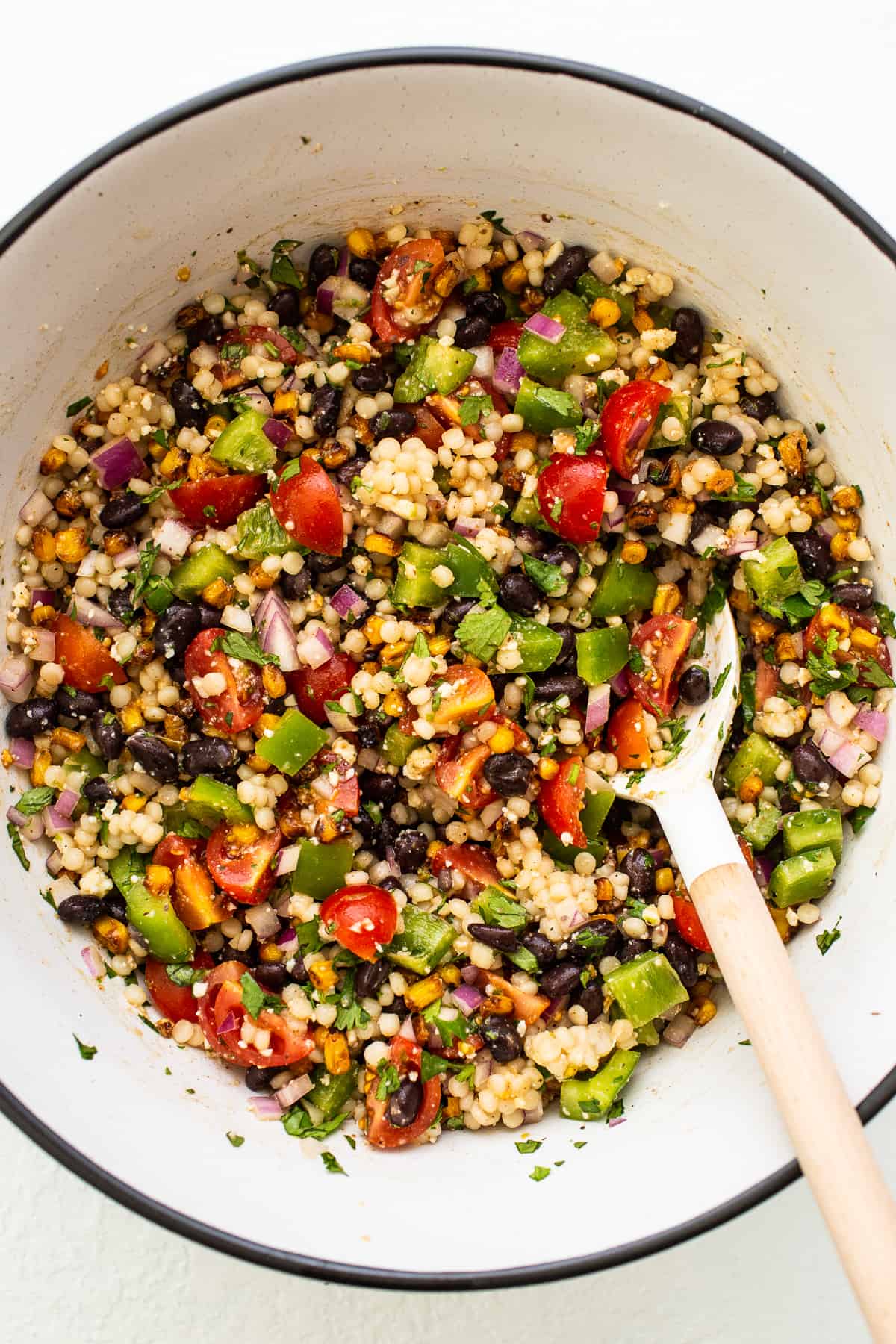 couscous salad with spoon in bowl.