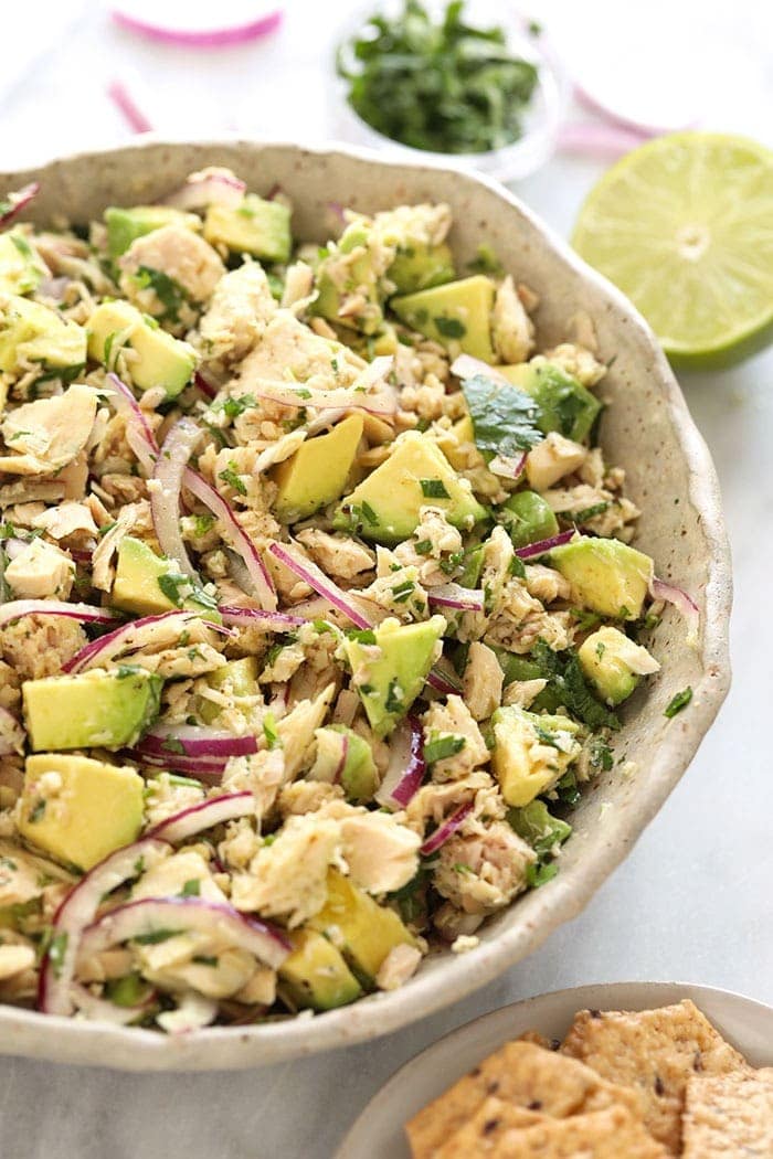 avocado tuna salad in a bowl next to crackers.