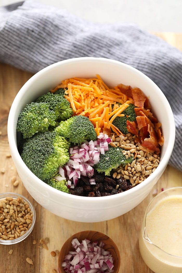 Ingredients for healthy broccoli salad with bacon in a bowl.