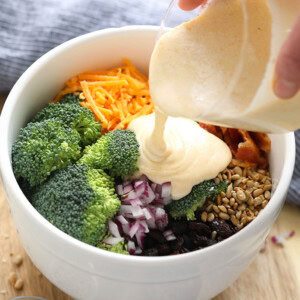 pouring dressing on broccoli salad.