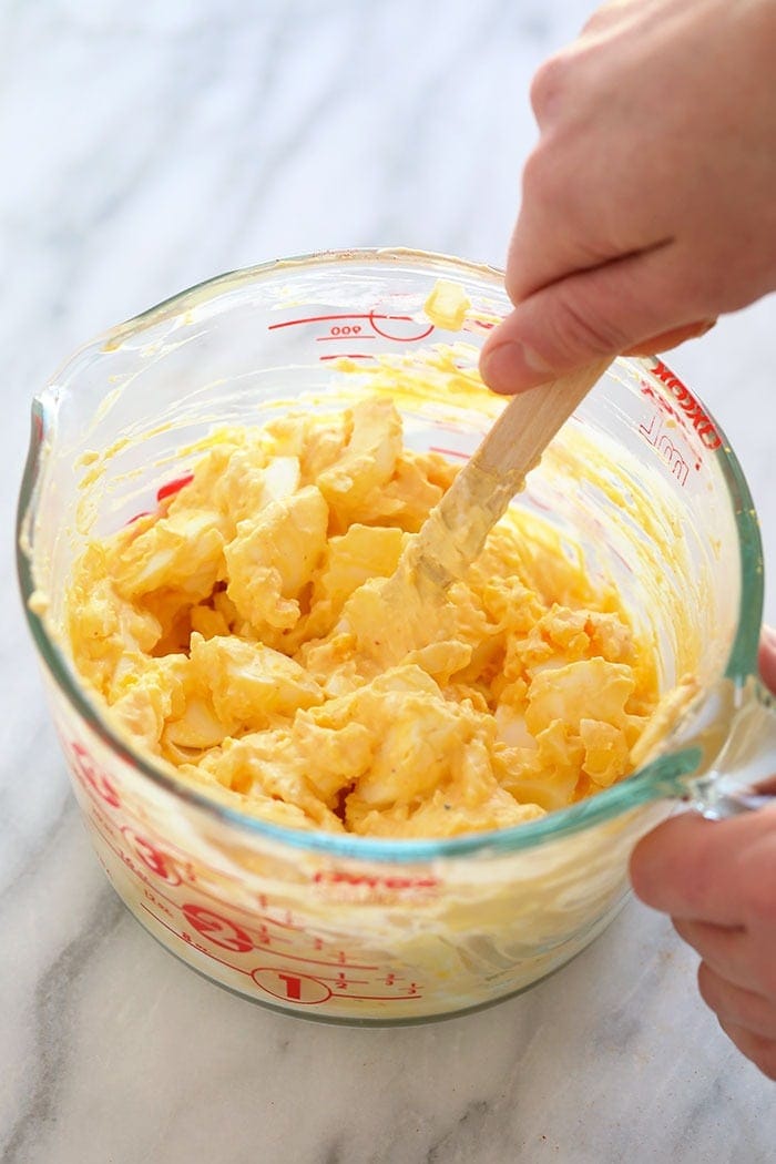 Healthy egg salad ingredients being mixed together.