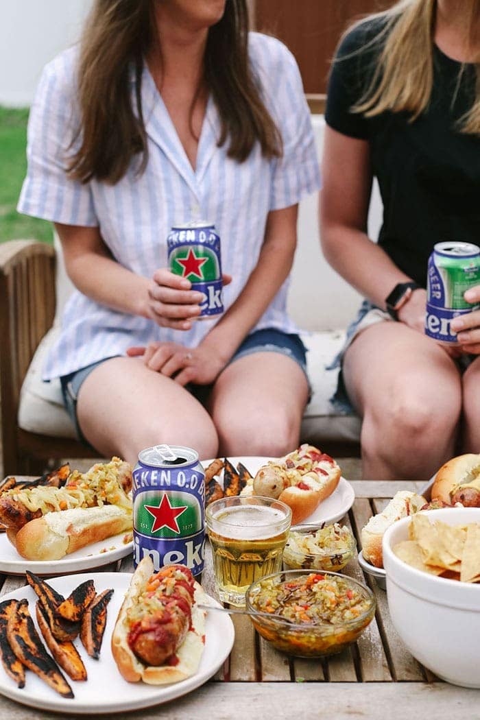 2 girls eating beer brats and drinking beers