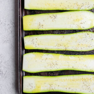 sliced zucchini on baking sheet.