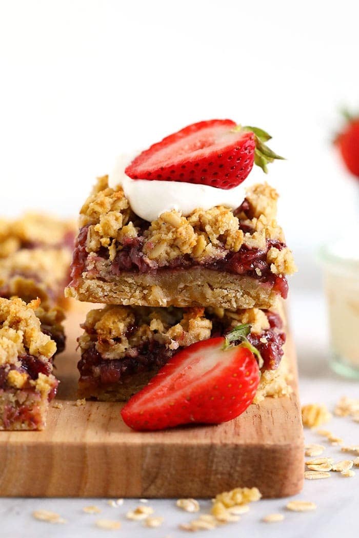 healthy strawberry oatmeal bars stacked and topped with fresh strawberries