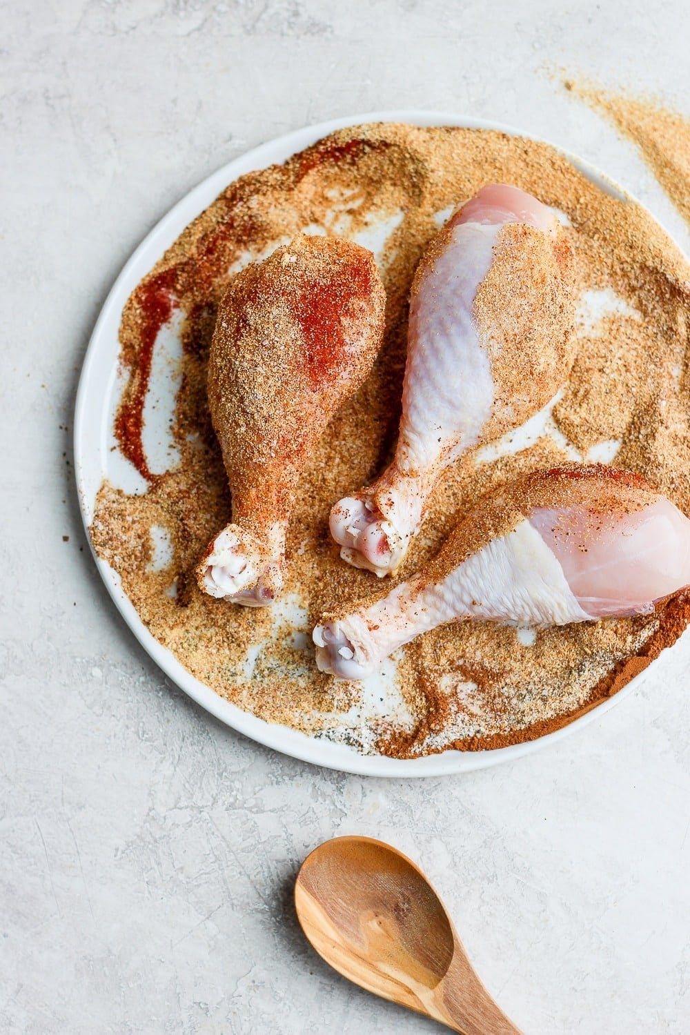 chicken legs rolled in dry rub on a plate