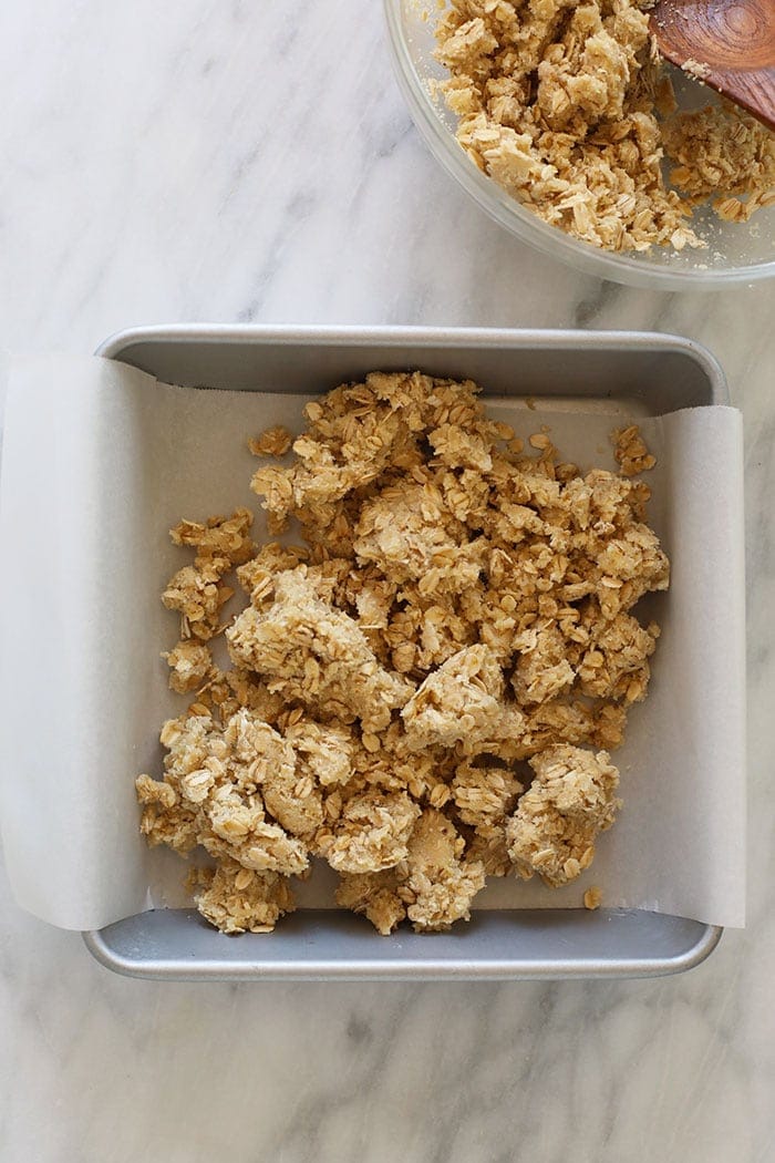 crust and crumble topping in a baking dish with parchment paper