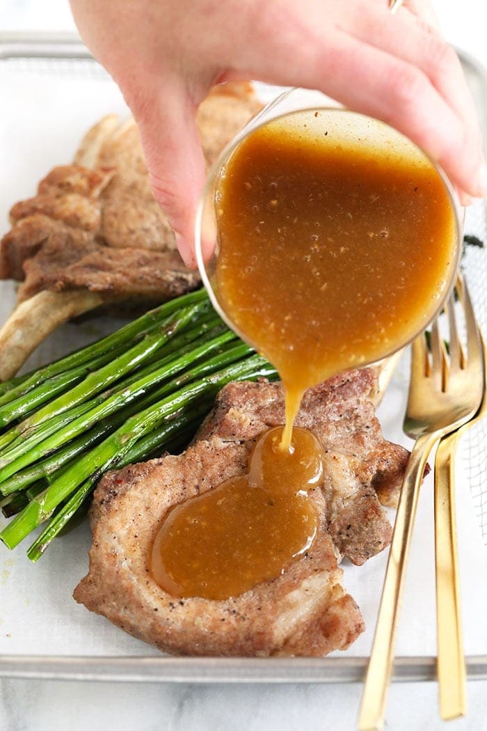 pouring gravy on pork chops