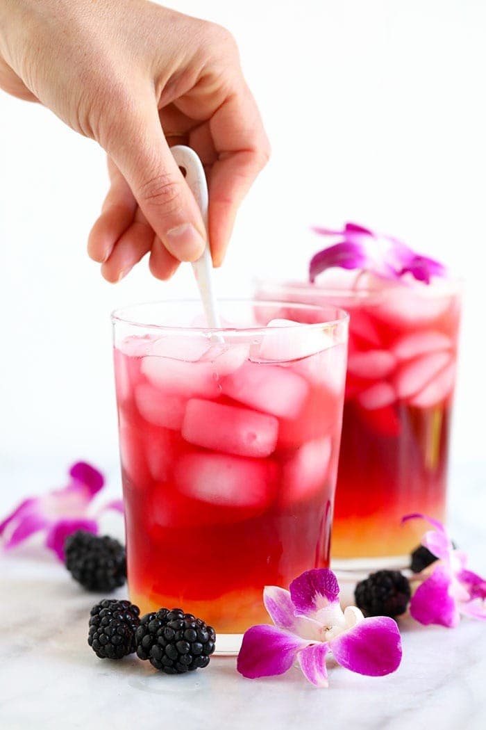 arnold palmer drink being stirred in a glass with a spoon