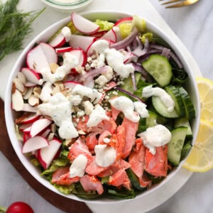 Salmon salad served in a white bowl with radishes.