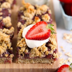 strawberry oatmeal bar topped with whipped cream and a fresh strawberry