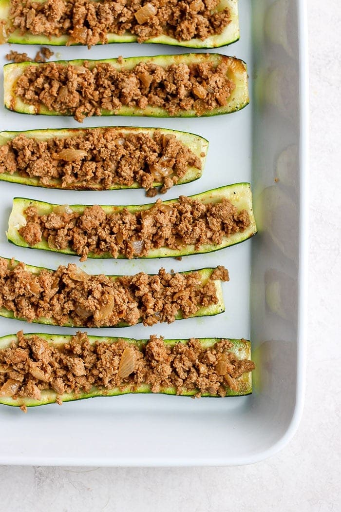 taco zucchini boats ready to be topped with cheese and finished on the grill