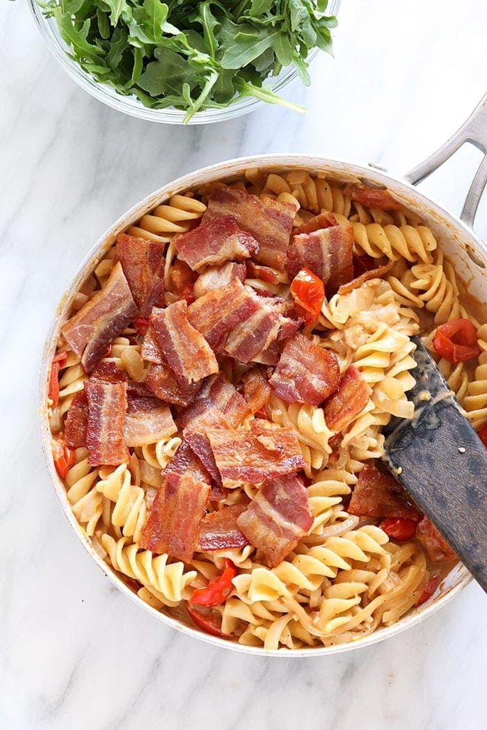 chopped bacon being mixed into a BLT pasta