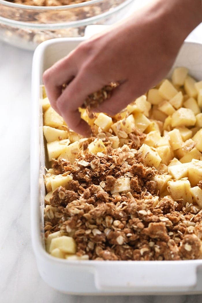 sprinkling crumble topping on apples