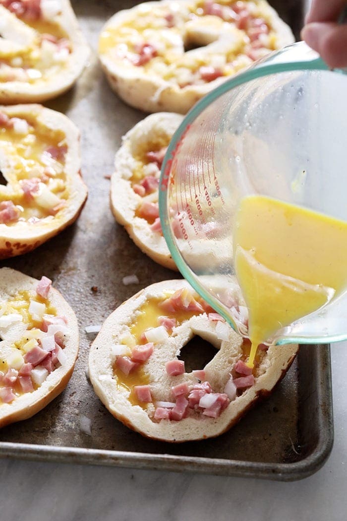 Pouring egg into hallowed out bagels