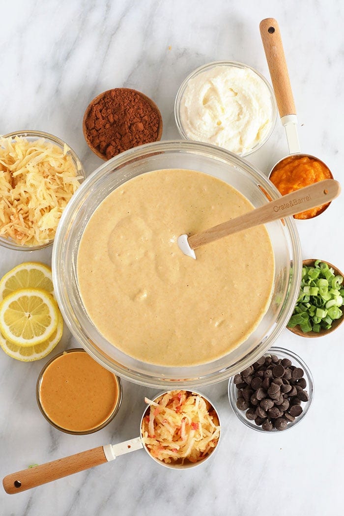 Pancake batter in a bowl with ingredients surrounding it.