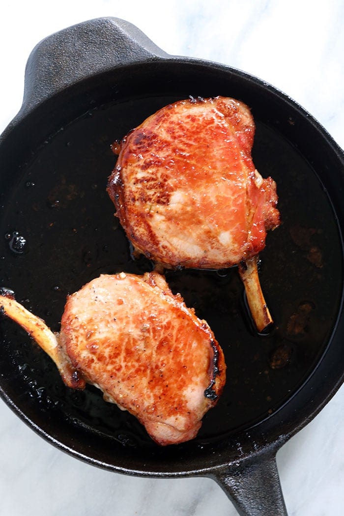 2 pork chops in cast iron skillet