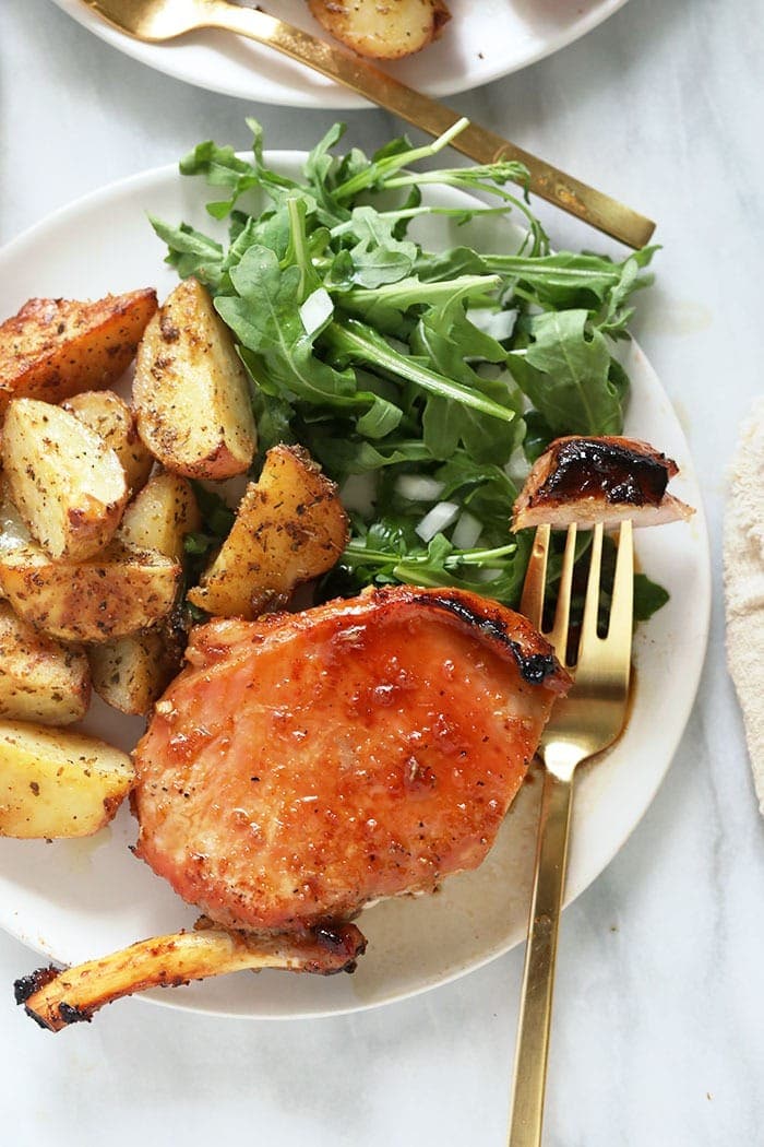 bone in pork chops with roasted potatoes on plate