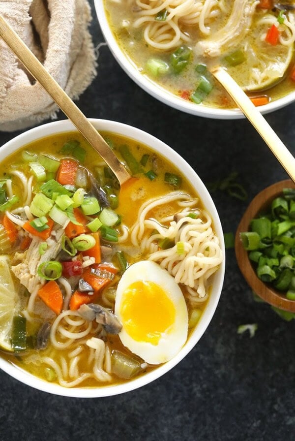 chicken noodle soup in a bowl with a soft boiled egg