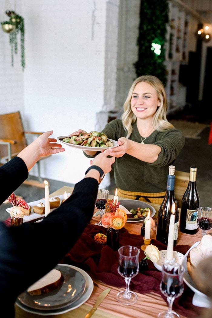 girl holding roasted brussels sprouts in bowl