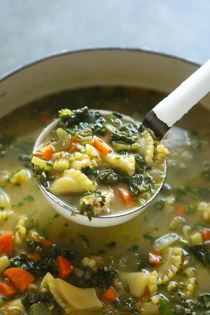 spicy chicken noodle soup in a ladle 