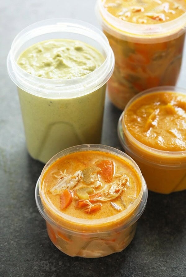 Three plastic containers of frozen soup.