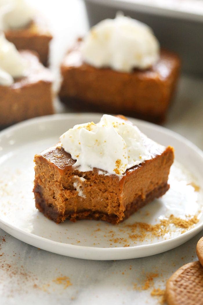 pumpkin cheesecake bar with a bite taken out of it on a plate