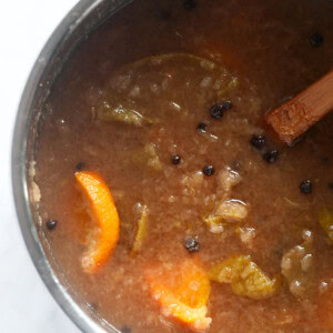 A homemade bowl of soup with a wooden spoon in it, made with fresh ingredients and flavors reminiscent of homemade apple cider.