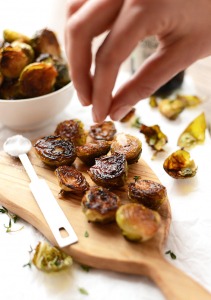 roasted brussel sprouts being sprinkled with olive oil