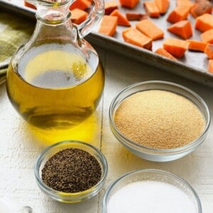 Sweet potatoes with oil, salt, and spices on a table.