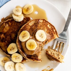 Peanut butter banana pancakes neatly arranged on a plate.