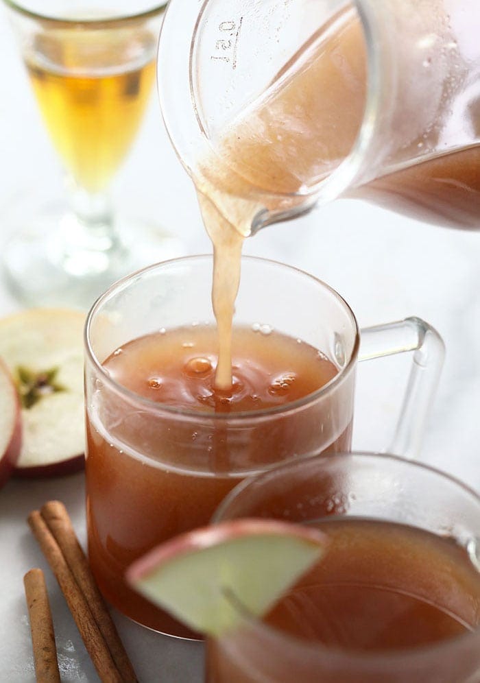 spiked apple cider being poured in a mug