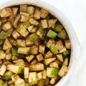 Sliced apples arranged in a white bowl, perfect for making apple pie bars.