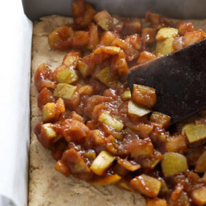 An apple pie bar baked on a baking pan, served with a spatula.