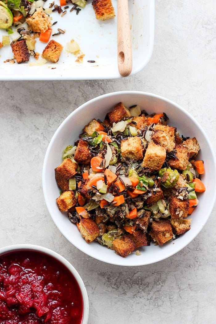 cornbread stuffing in a bowl next to cranberry sauce