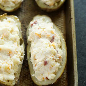 Four twice baked potatoes on a baking sheet.