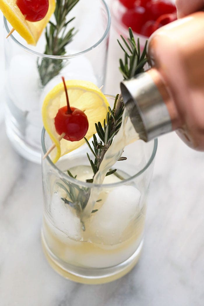 pouring a rosemary collins in a glass