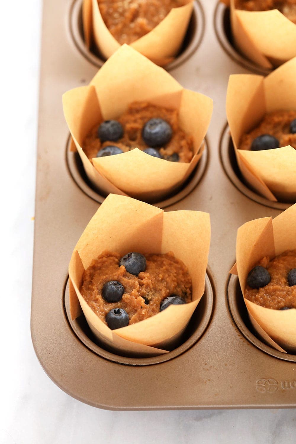 almond flour blueberry muffins in muffin liners ready to be baked