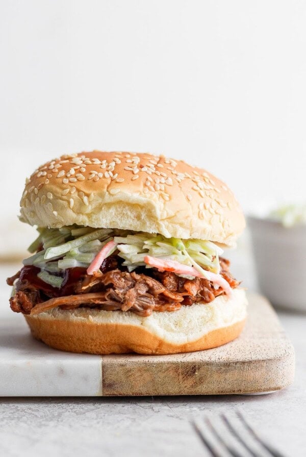 pulled pork in bun on cutting board