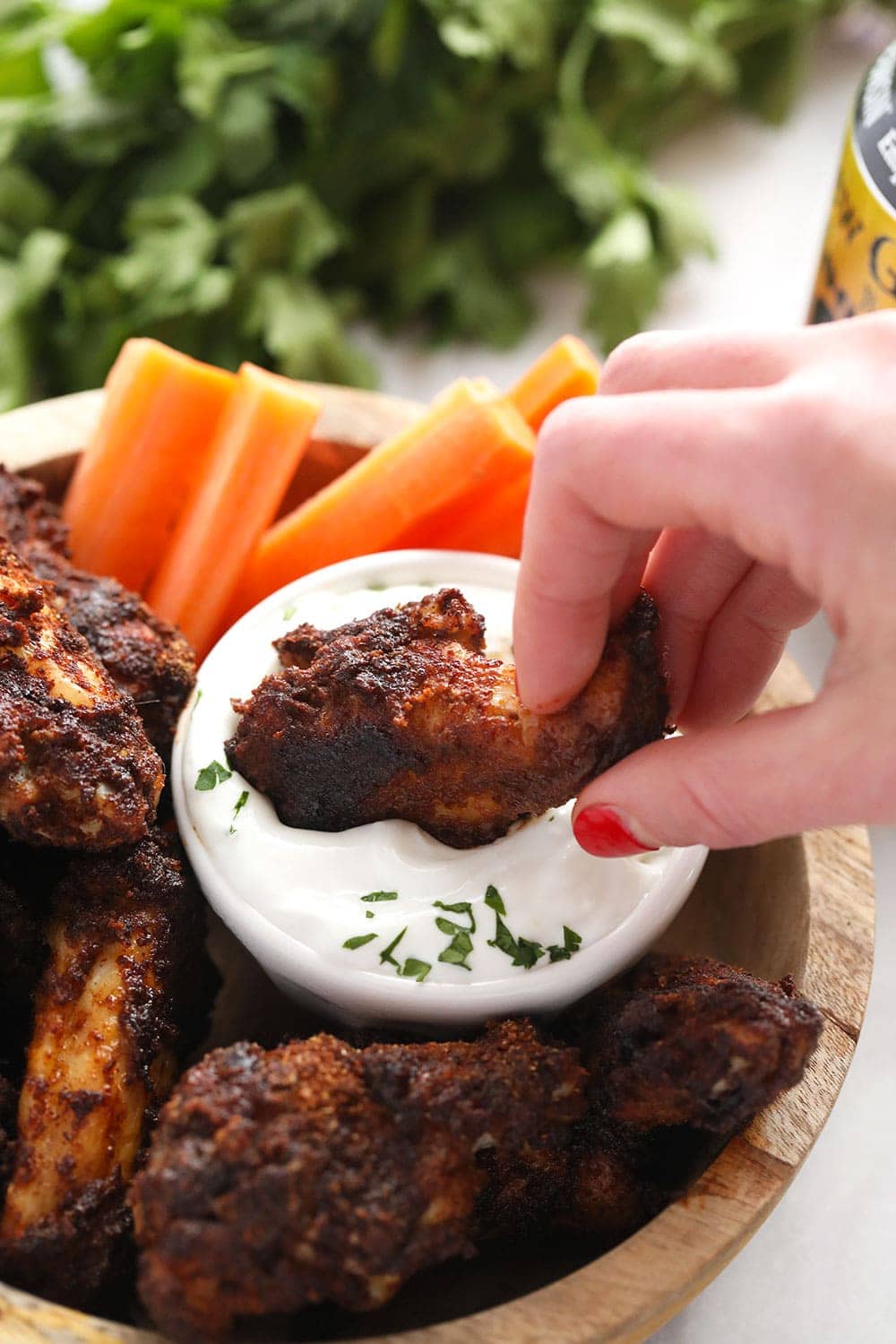 Dipping a chicken wing into blue cheese dressing