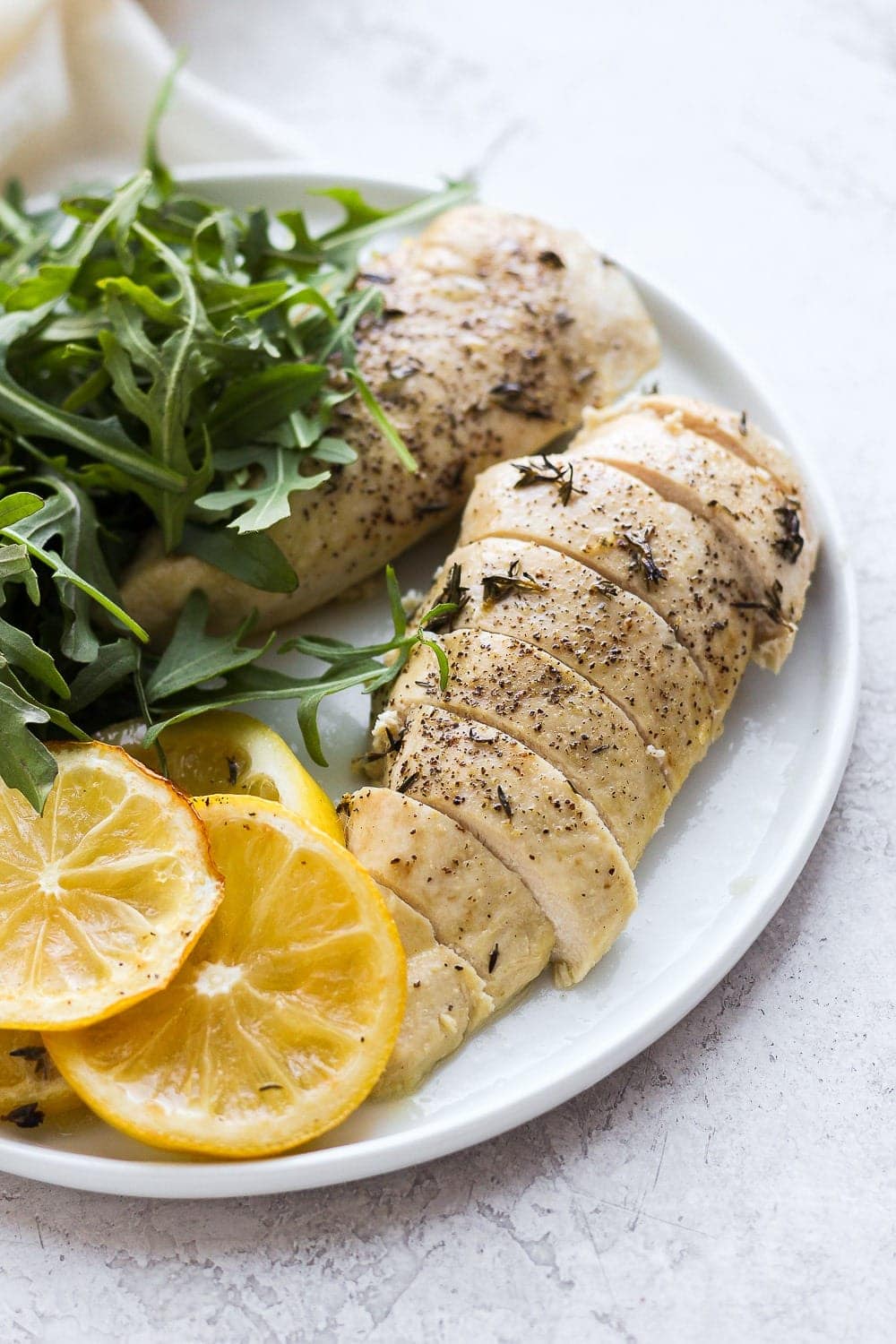 Sliced baked lemon chicken on plate.