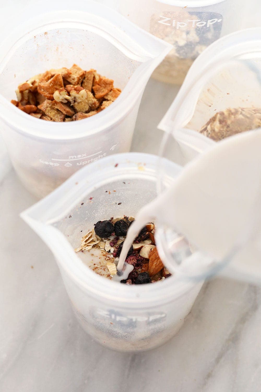 instant oatmeal 4 ways mixed in bowls with milk being poured over them