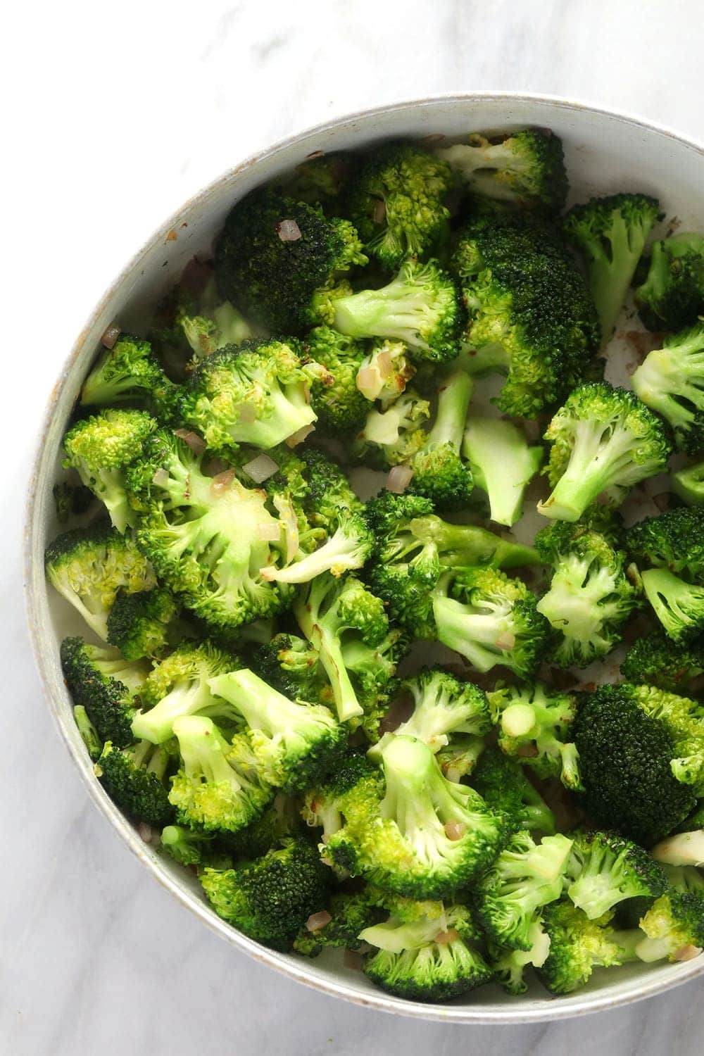 sautéed broccoli and diced onion in a skillet