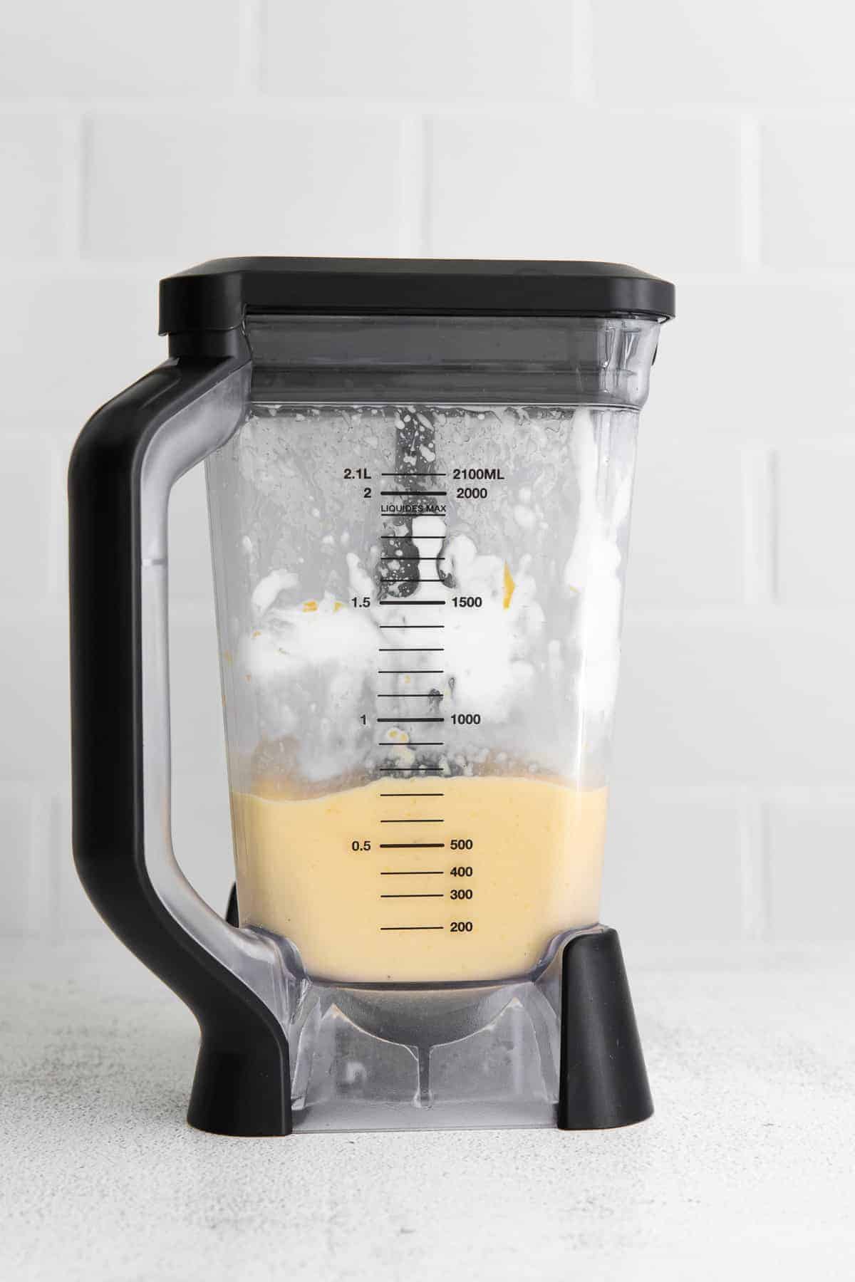 Creamy mango smoothie in a blender.